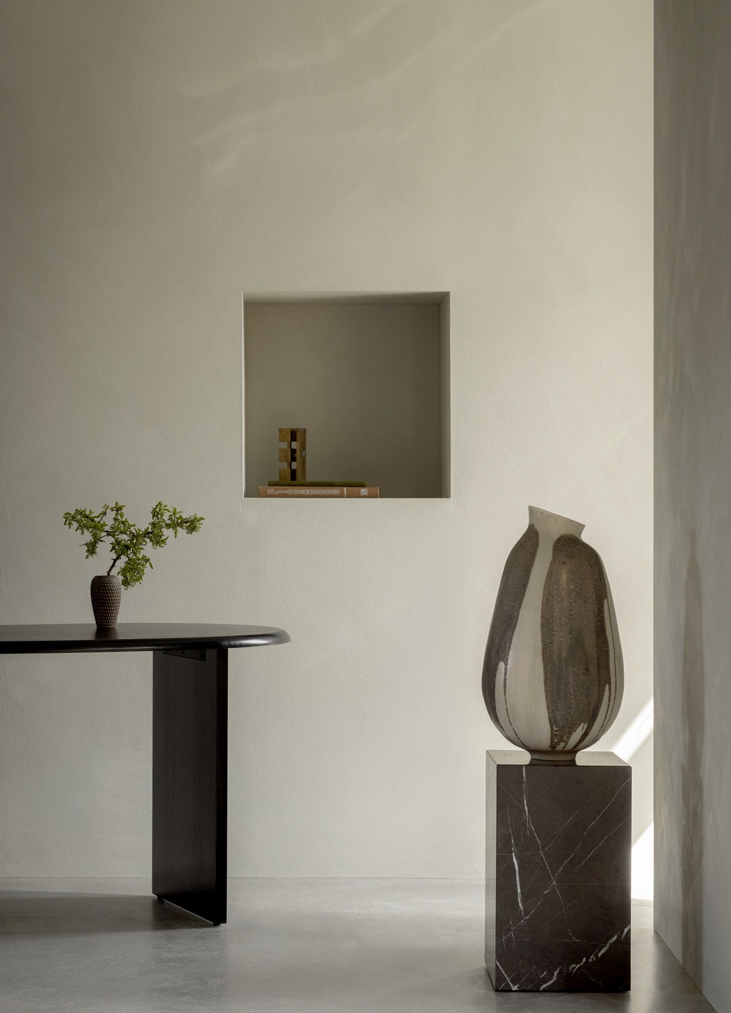 Audo Copenhagen Eclipse Desk Schreibtisch aus dunklem Holz mit minimalistischer Dekoration in einem hellen Raum.