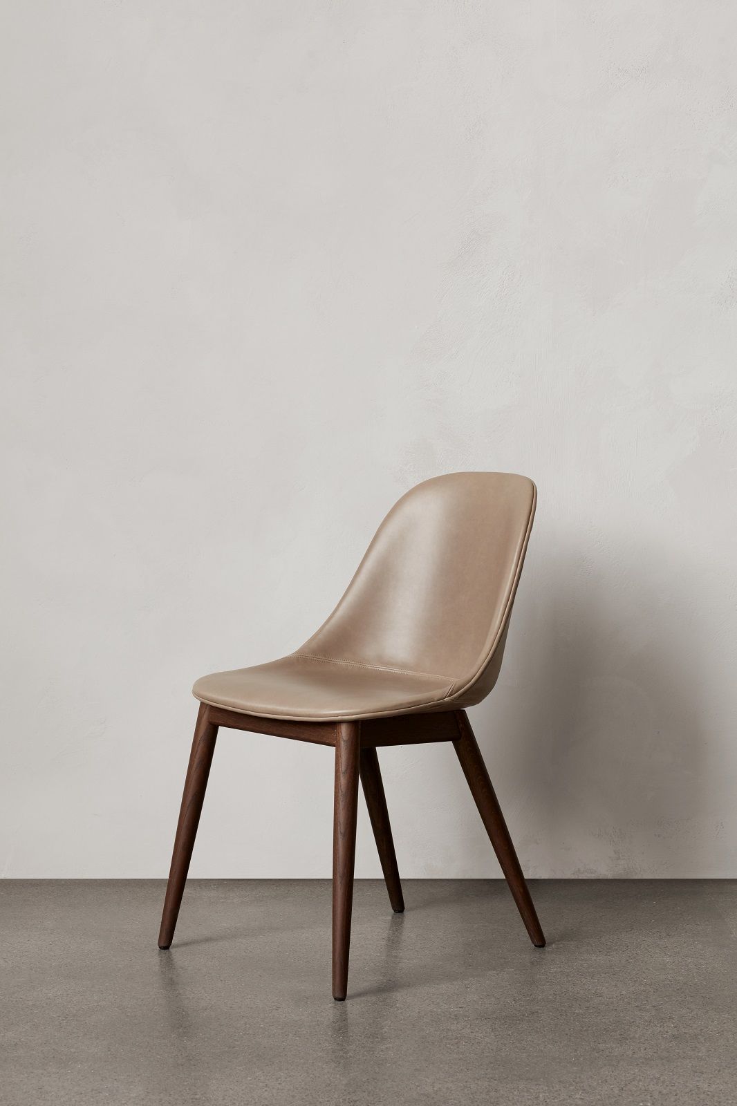 Audo Copenhagen Harbour Side Dining Chair mit beigem Lederbezug und dunklem Holzgestell.