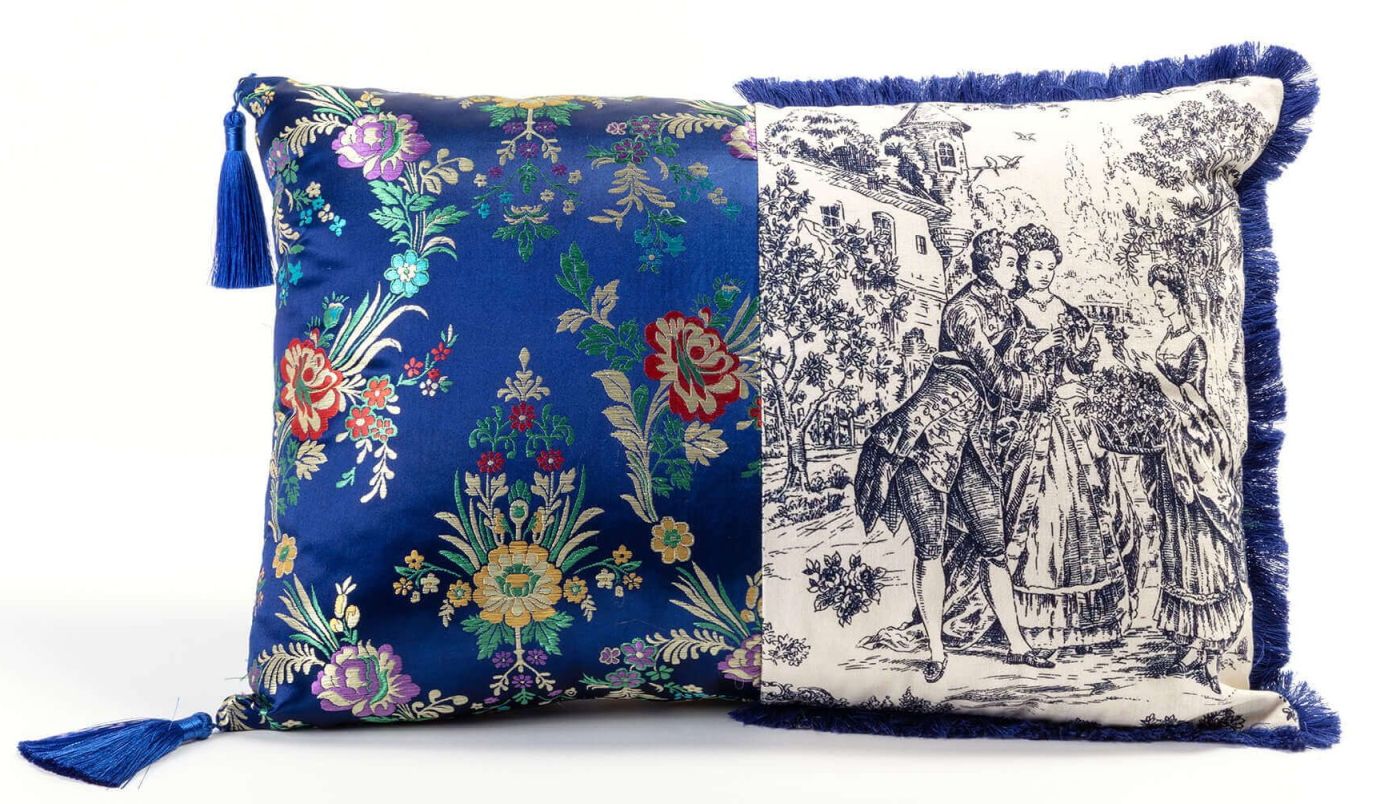 Hybrid Pillows Kissen: Blaues Zierkissen mit Blumenmuster und Kissen mit Toile-de-Jouy-Motiv und Fransen.