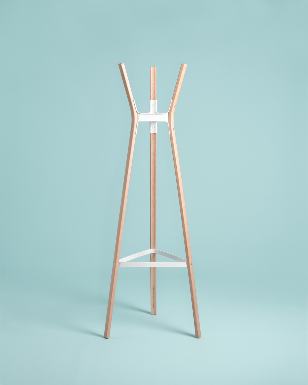 Steelwood Coat Stand Garderobenständer von Magis, moderne Holzgarderobe mit weißem Metallrahmen vor hellblauem Hintergrund.