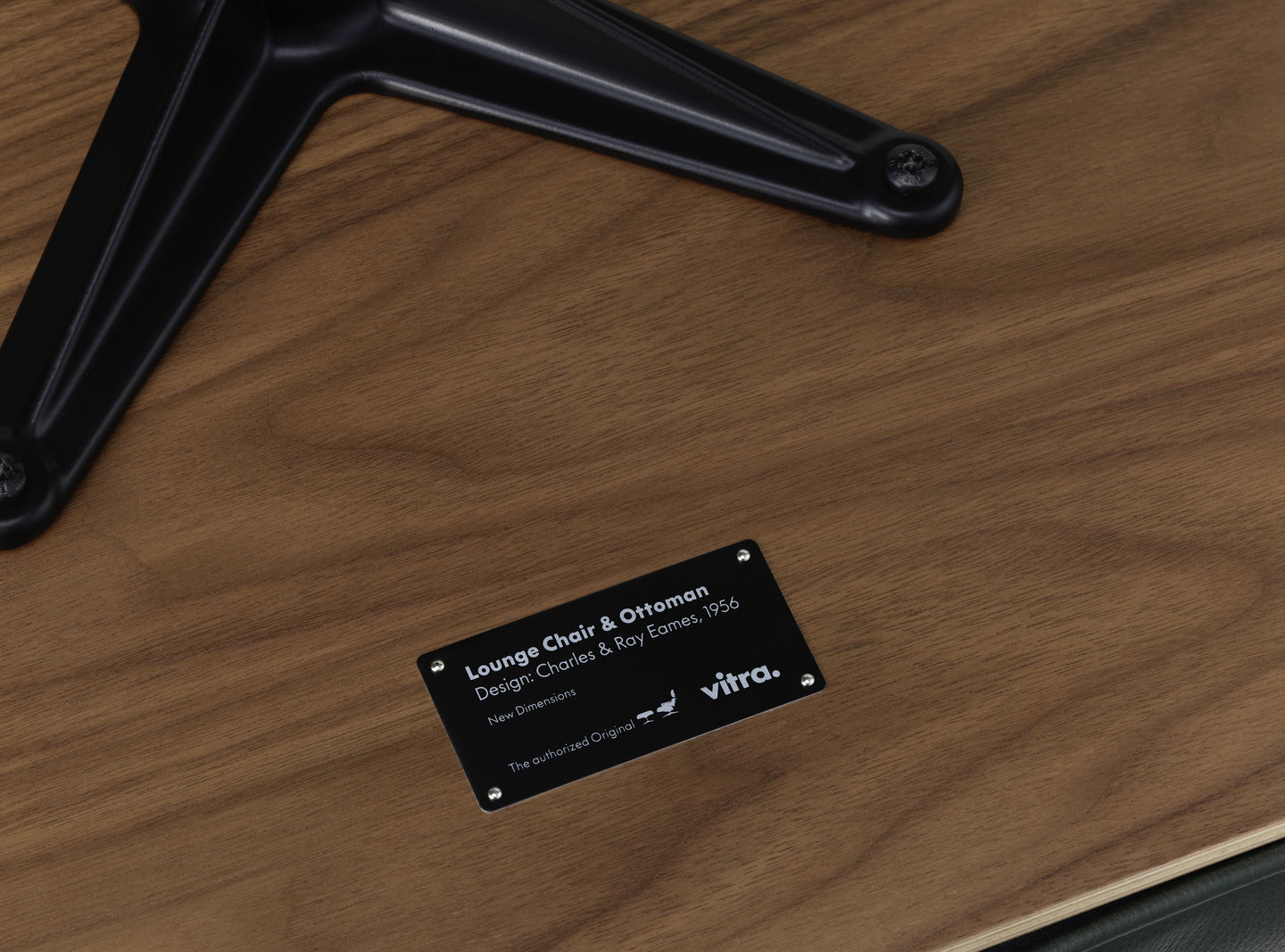 Detailaufnahme Eames Lounge Chair & Ottoman von Vitra, Fokus auf Holzstruktur und Herstellerplakette.