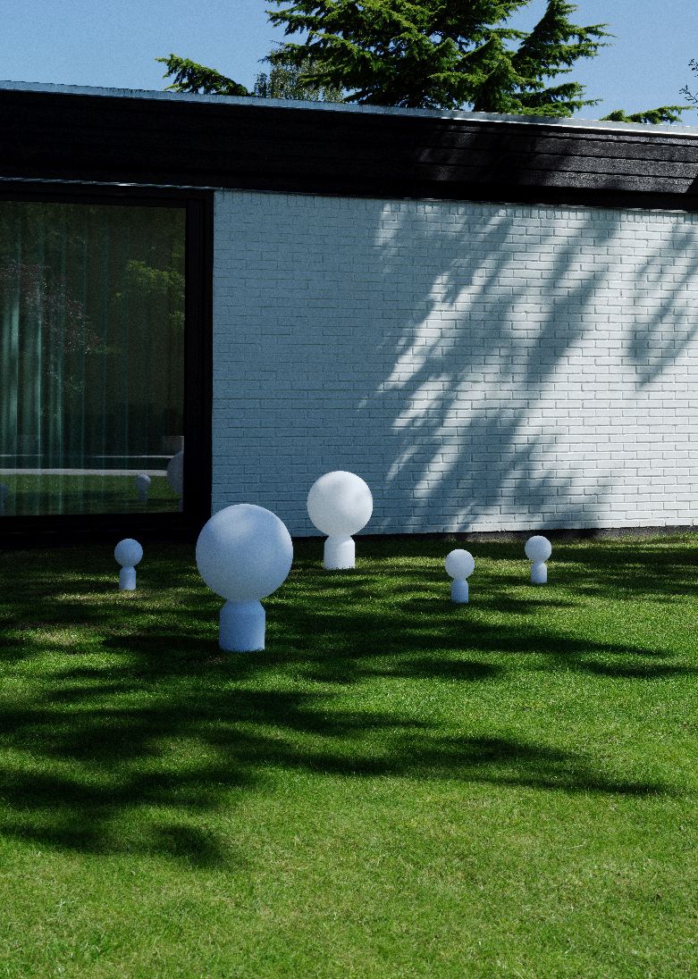 Mehrere Yo Lamp Akkuleuchten von Normann Copenhagen in verschiedenen Größen auf einer grünen Rasenfläche.