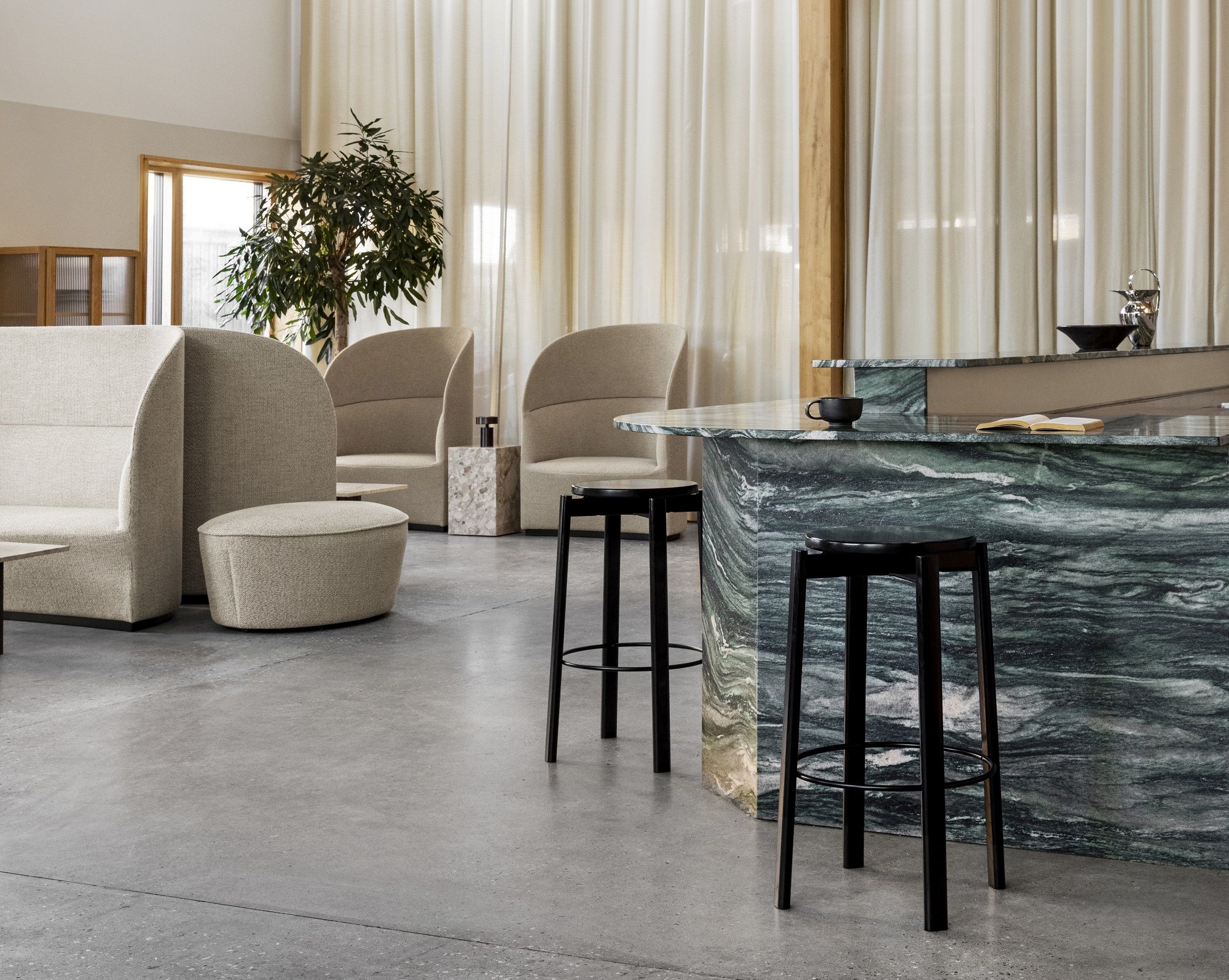 Passage Bar Stool von Audo Copenhagen aus schwarzem Holz vor einer grünen Marmorbar.