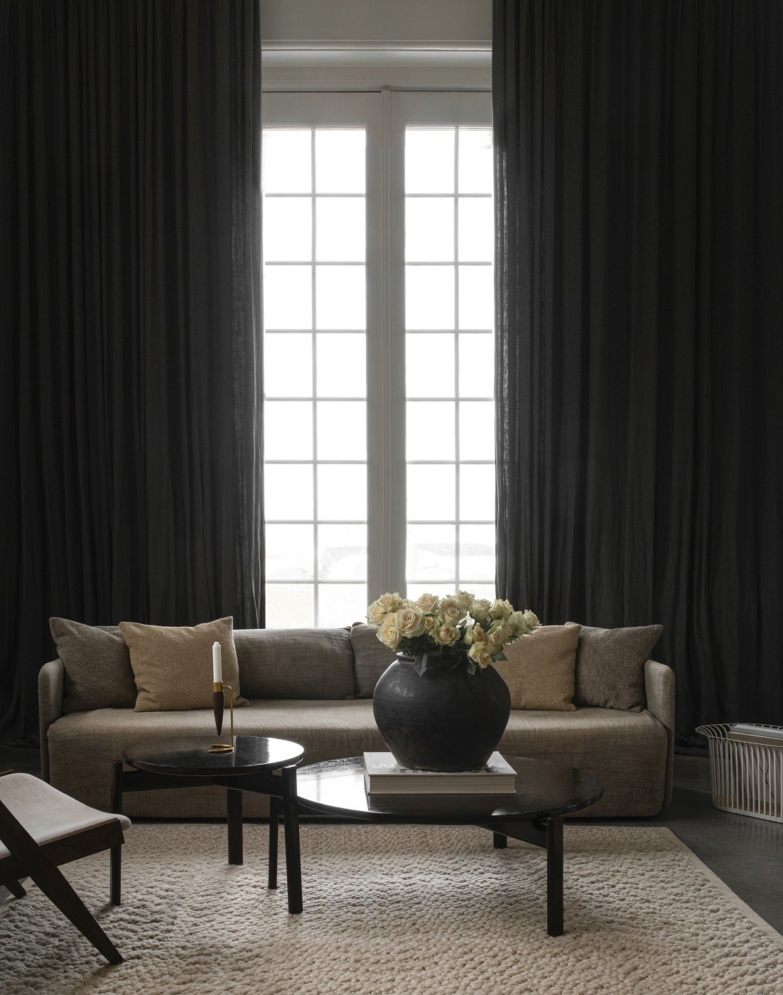 Beiger Gravel Rug Teppich von Audo Copenhagen in einem stilvollen Wohnzimmer mit Sofa und Tisch.