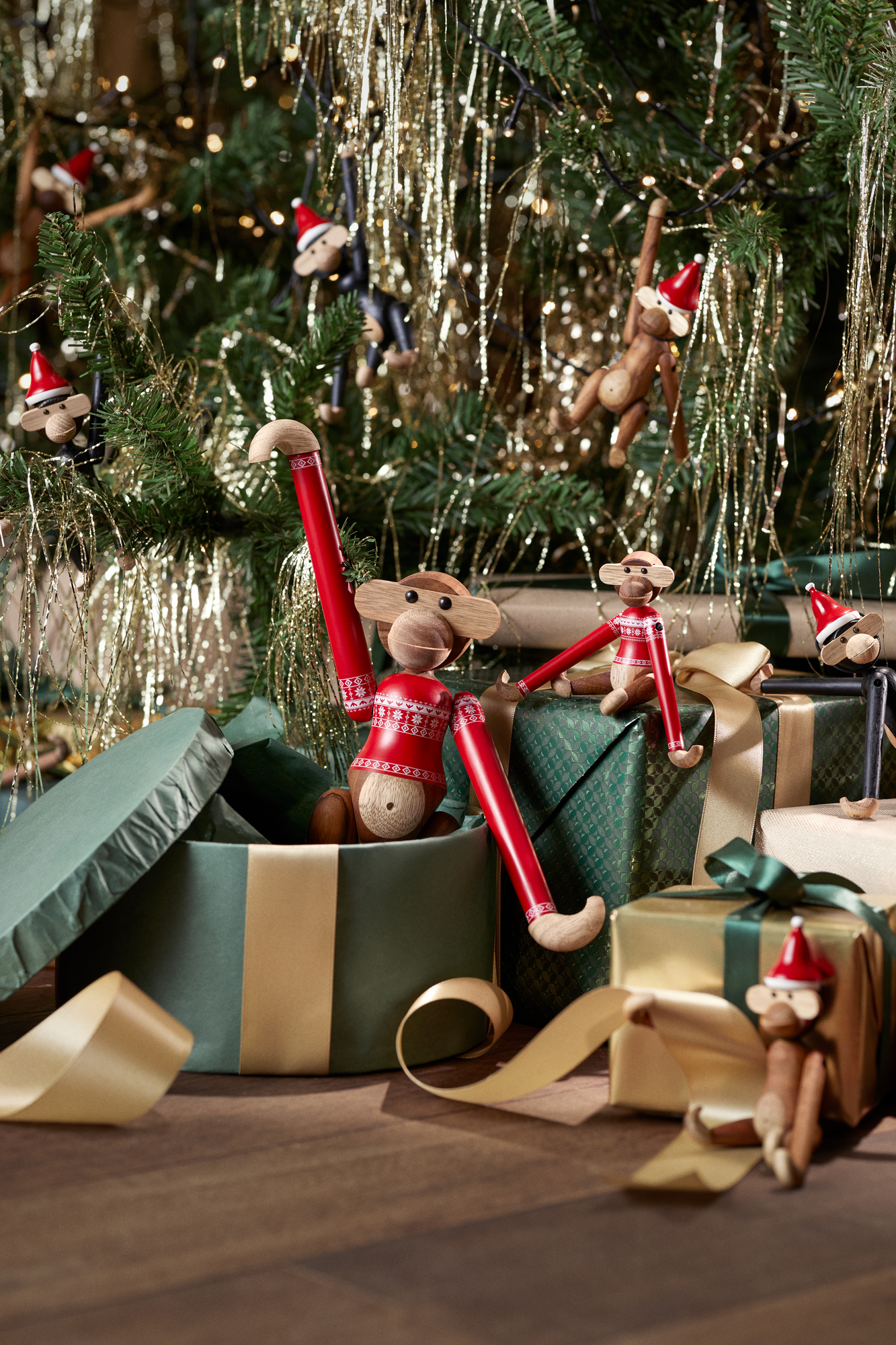Kay Bojesen Holz Affe Christmas Jumper 2024: Festliche Weihnachtsdekoration mit kleinen Holzfiguren am Weihnachtsbaum und auf Geschenken.
