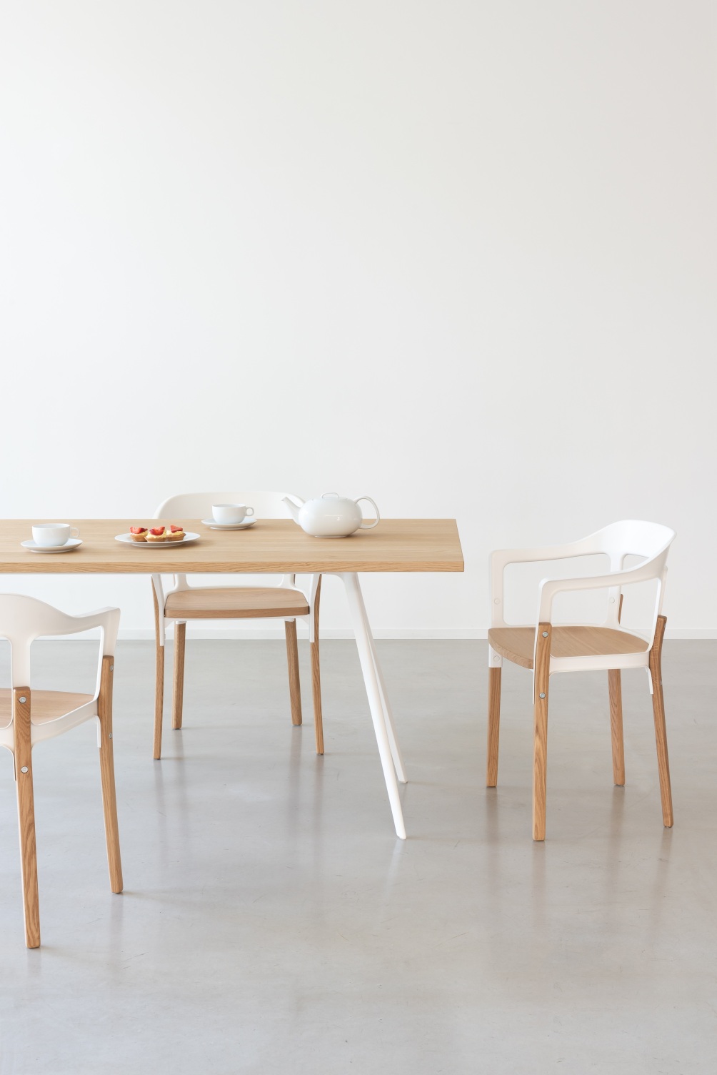 Magis Steelwood Chair Stühle in Weiß und Holz an Esstisch mit Teegeschirr.