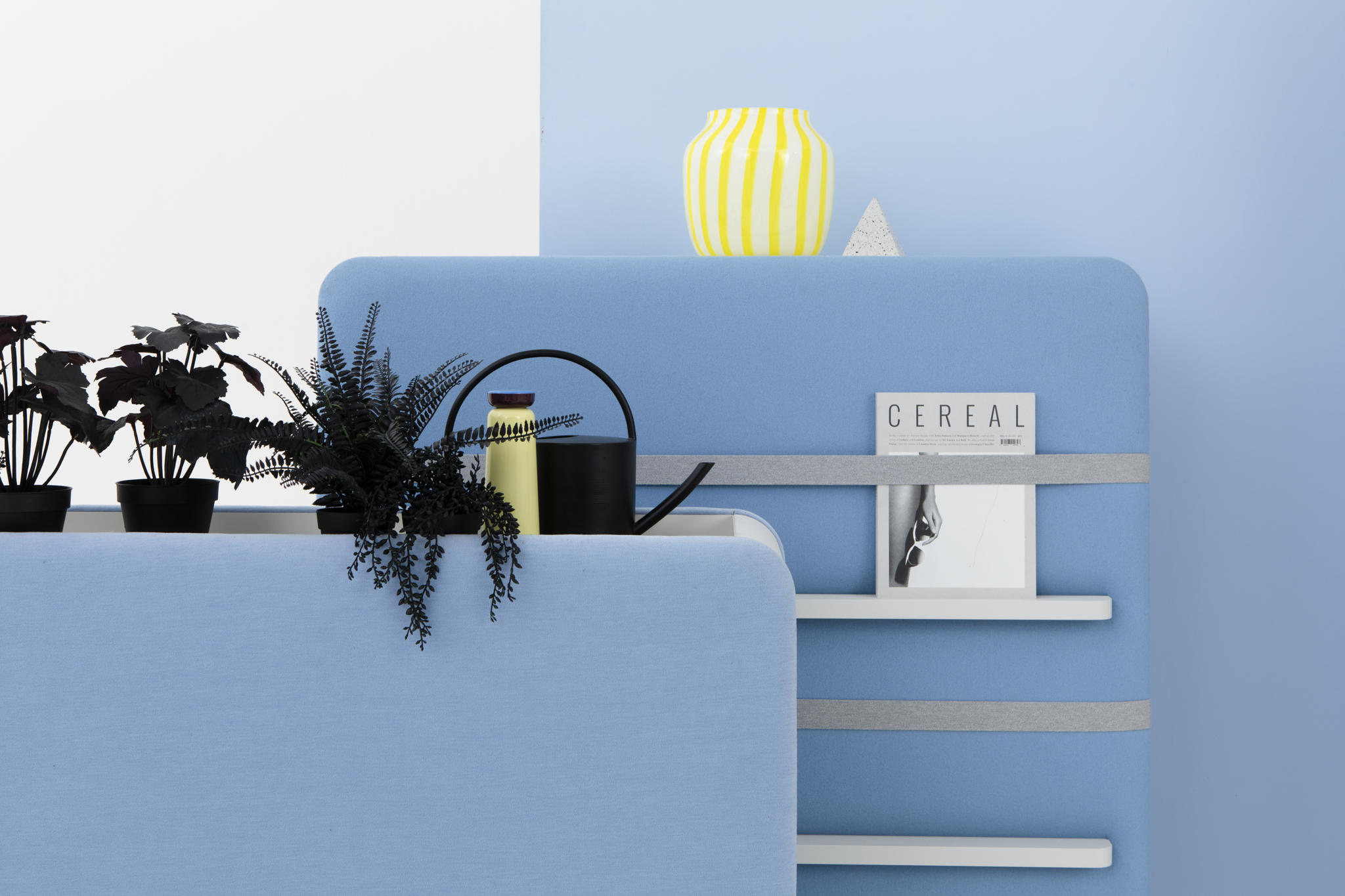 Cascando Pillow Space Akustik-Raumteiler in Hellblau mit Pflanzen, Gießkanne und Regalen für Büro oder Wohnraum.