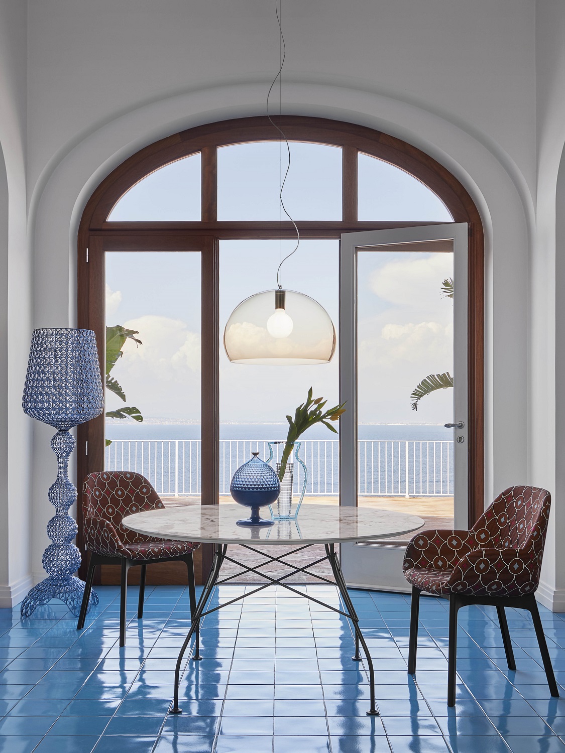 Big Fly FL/Y Pendelleuchte von Kartell über Esstisch mit Meerblick, moderne Hängelampe für Wohnraumbeleuchtung.