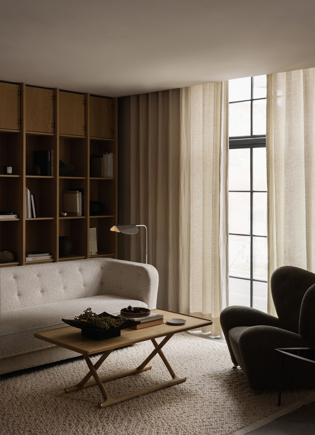 Audo Copenhagen Gravel Rug Teppich in einem Wohnzimmer mit Sofa und Sessel.