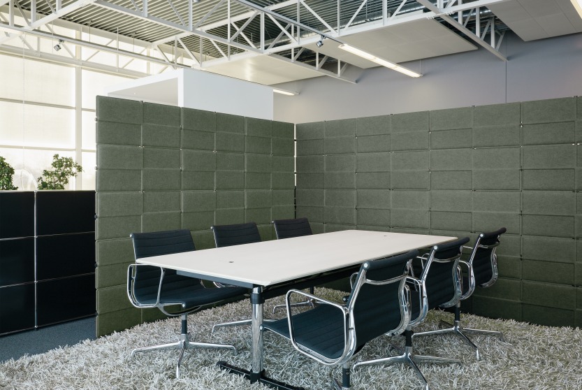 USM Haller Privacy Panels in Grün als Raumteiler in einem modernen Büro mit Konferenztisch.