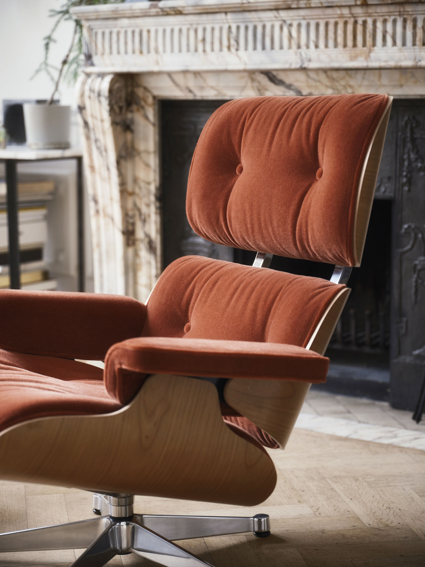 Detailaufnahme: Eames Lounge Chair mit Ottoman in Orange, Designklassiker von Vitra für stilvolles Wohnen.