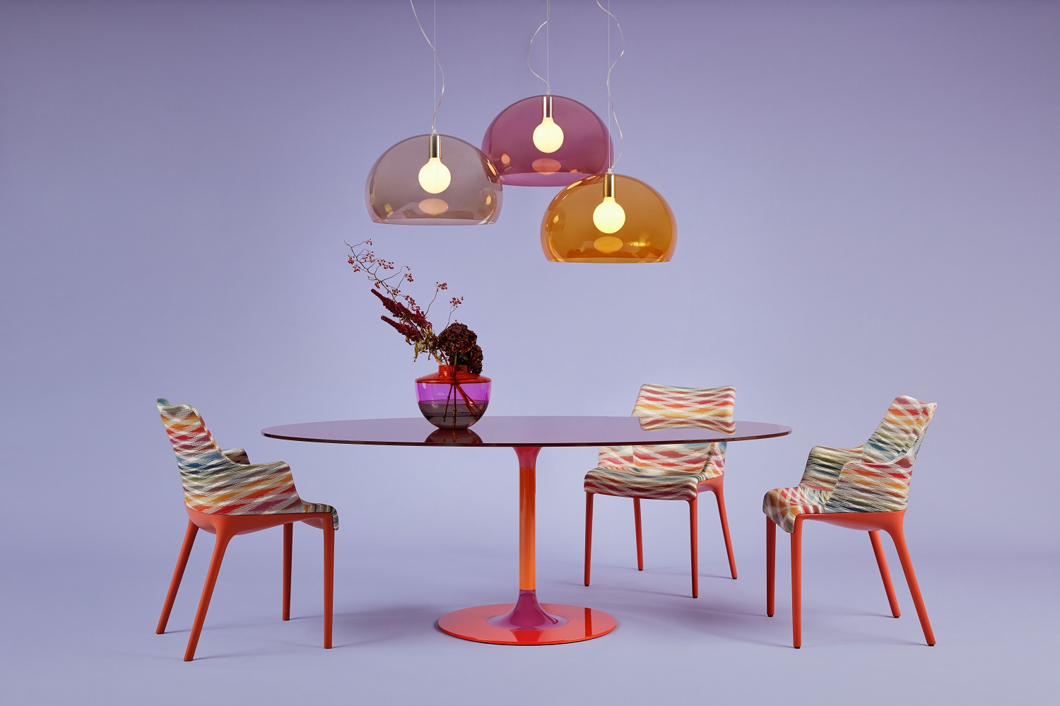 Big Fly FL/Y Pendelleuchten von Kartell in Braun, Lila und Orange über Esstisch mit Stühlen.