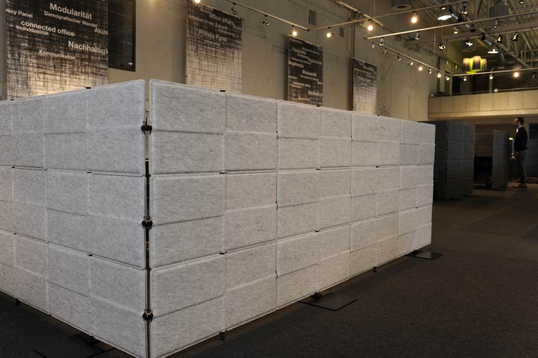 Graue USM Haller Privacy Panels als Raumteiler in einem Büro, verbunden mit schwarzen Verbindungsstücken.