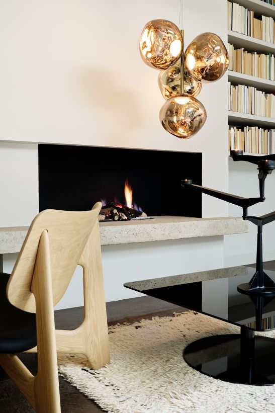 Nahaufnahme des Tom Dixon Spin Kerzenständers in einem modernen Wohnzimmer mit Kamin und Bücherregal.