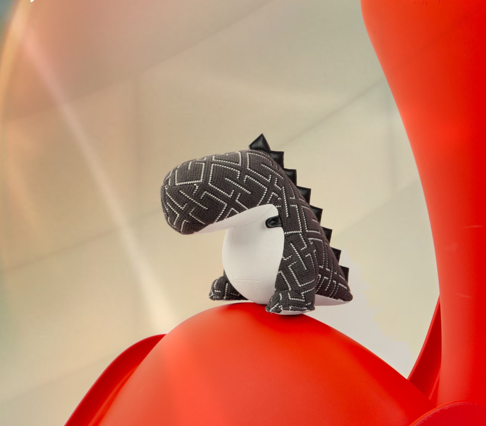Dunkelgraue Dinosaurier Buchstütze Bobo von Züny x KVADRAT auf roter Oberfläche, dekorative Kinderzimmer Deko.