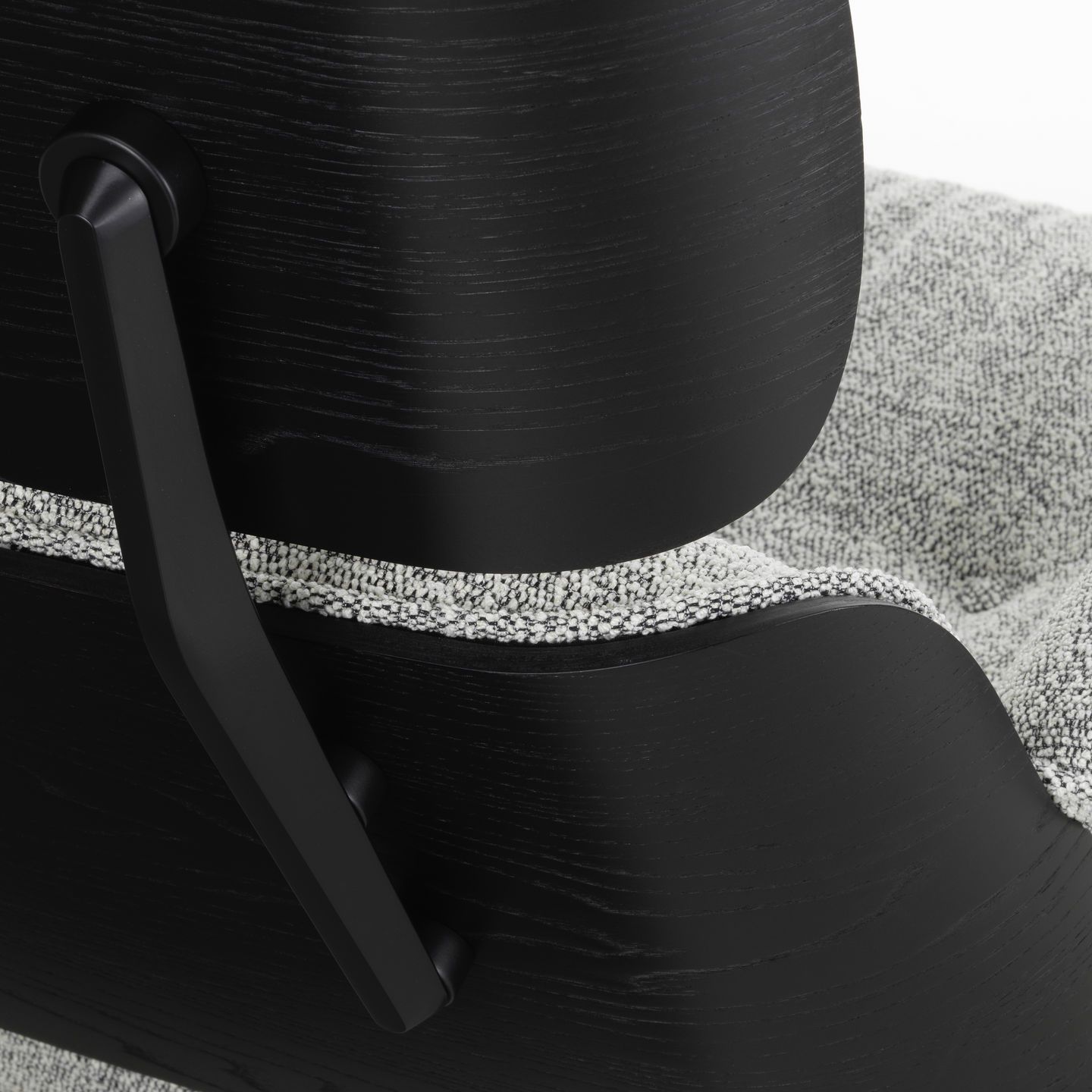 Detailansicht der Rückseite eines schwarzen Eames Lounge Chairs mit grau meliertem Stoffbezug.