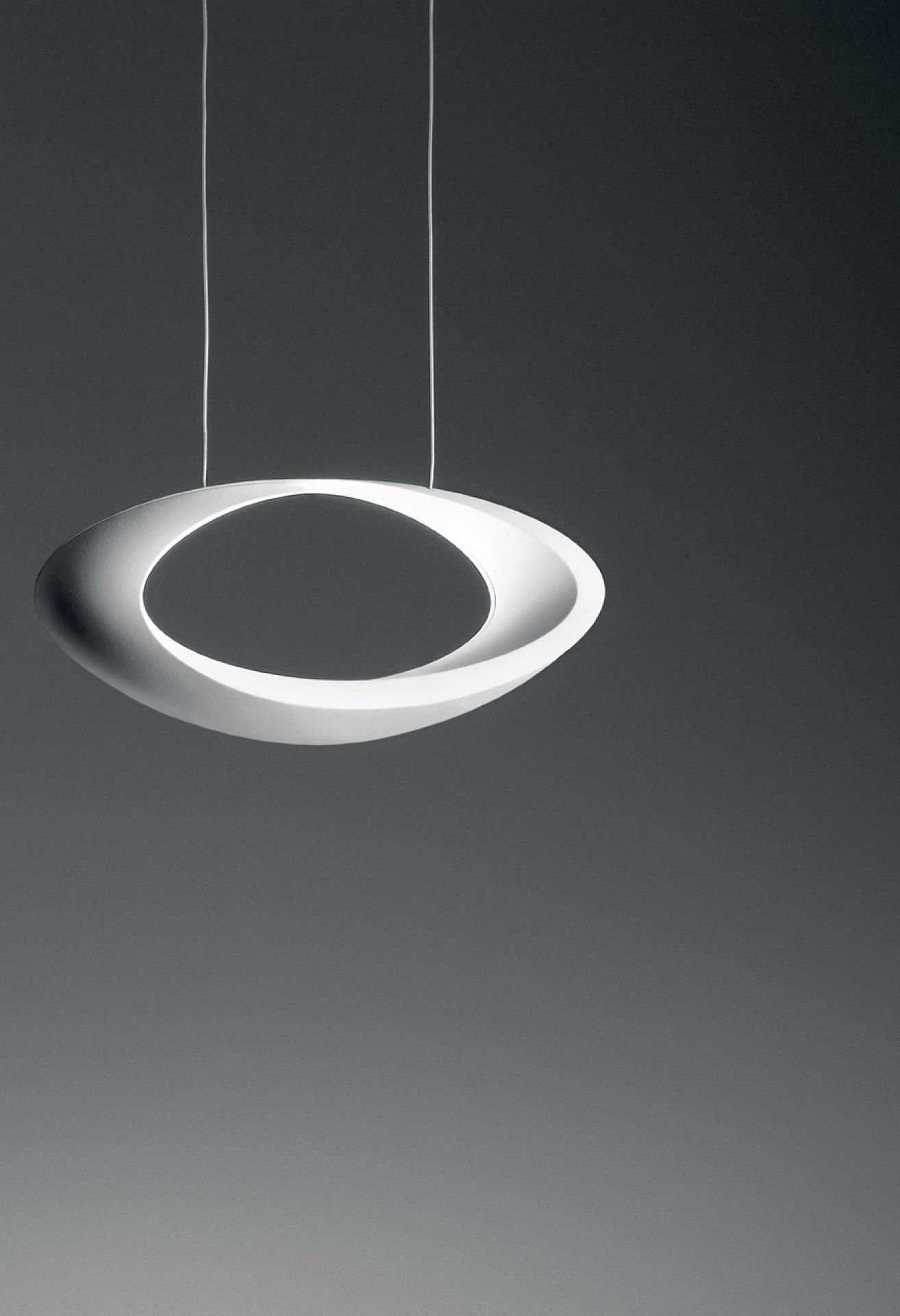 Weiße Cabildo LED Pendelleuchte von Artemide mit warmweißem Licht (2700K) an zwei dünnen Seilen.