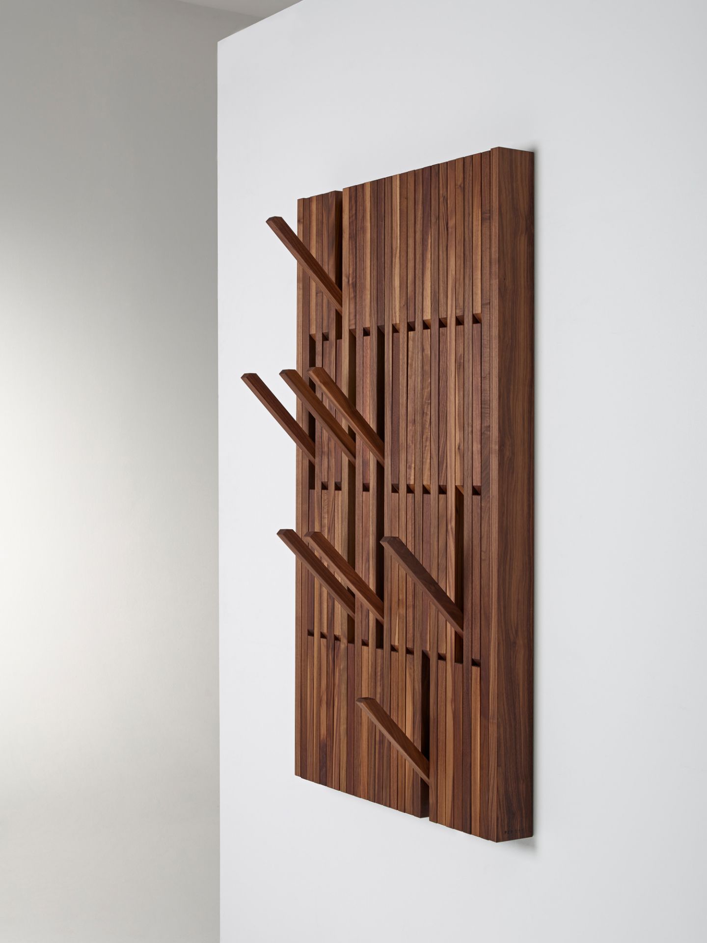Große Piano Wandgarderobe aus geöltem Walnussholz mit ausklappbaren Haken zur Wandmontage.