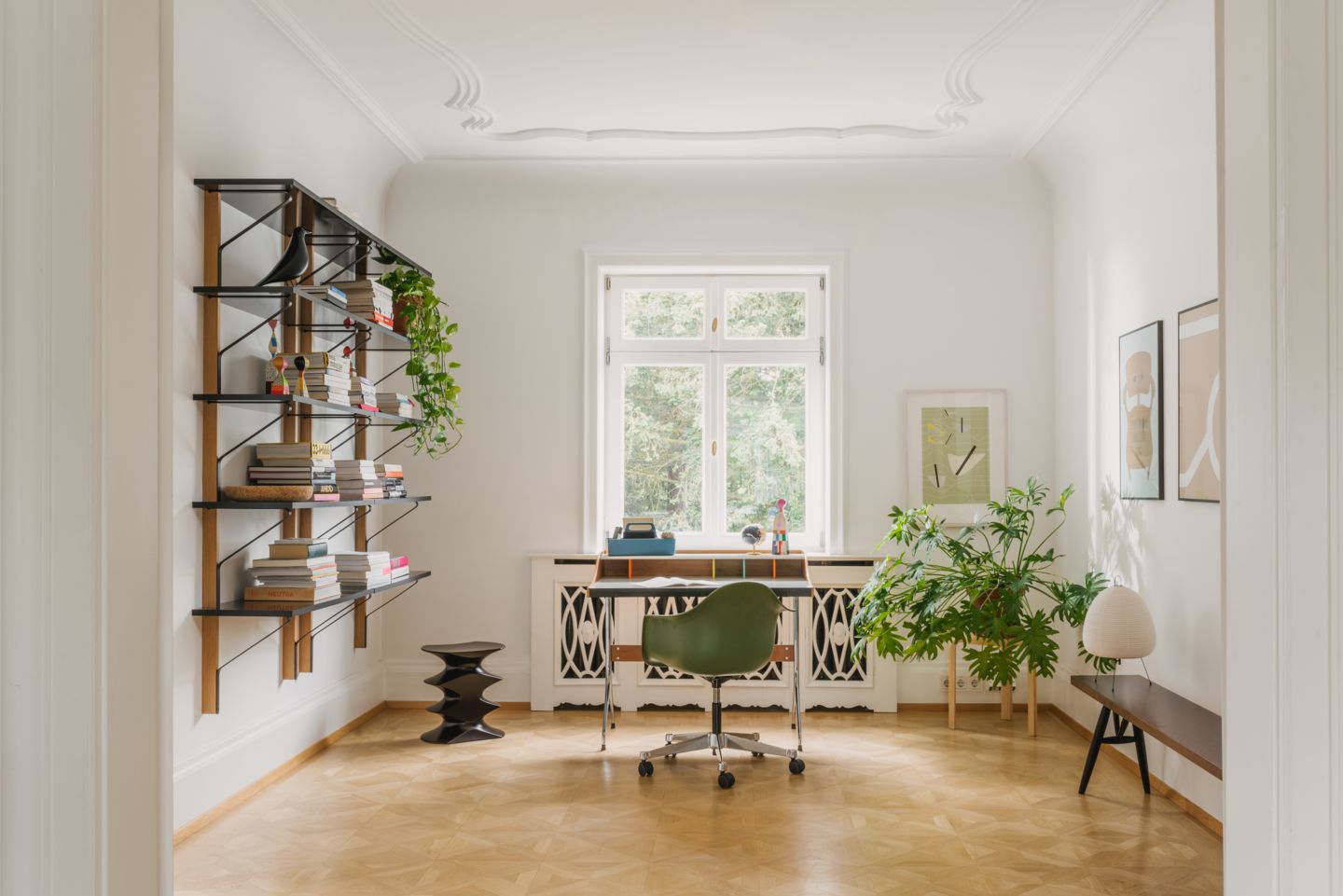 Büro mit Vitra Eames Plastic Arm Chair in Grün, Schreibtisch und Regalen.