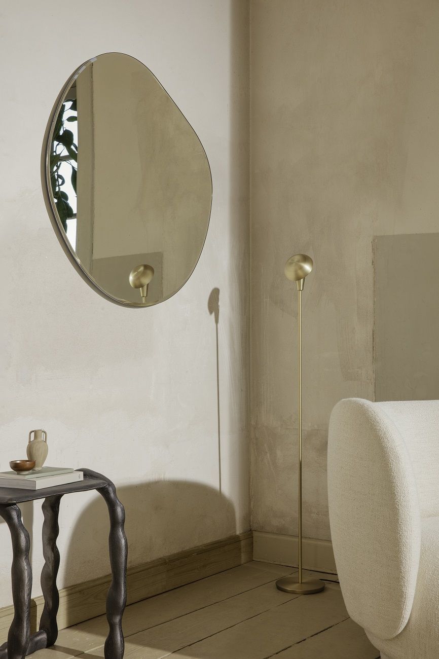 Nahaufnahme der goldenen Tiny Floor Lamp Stehleuchte von Ferm Living in einem stilvollen Wohnzimmer.