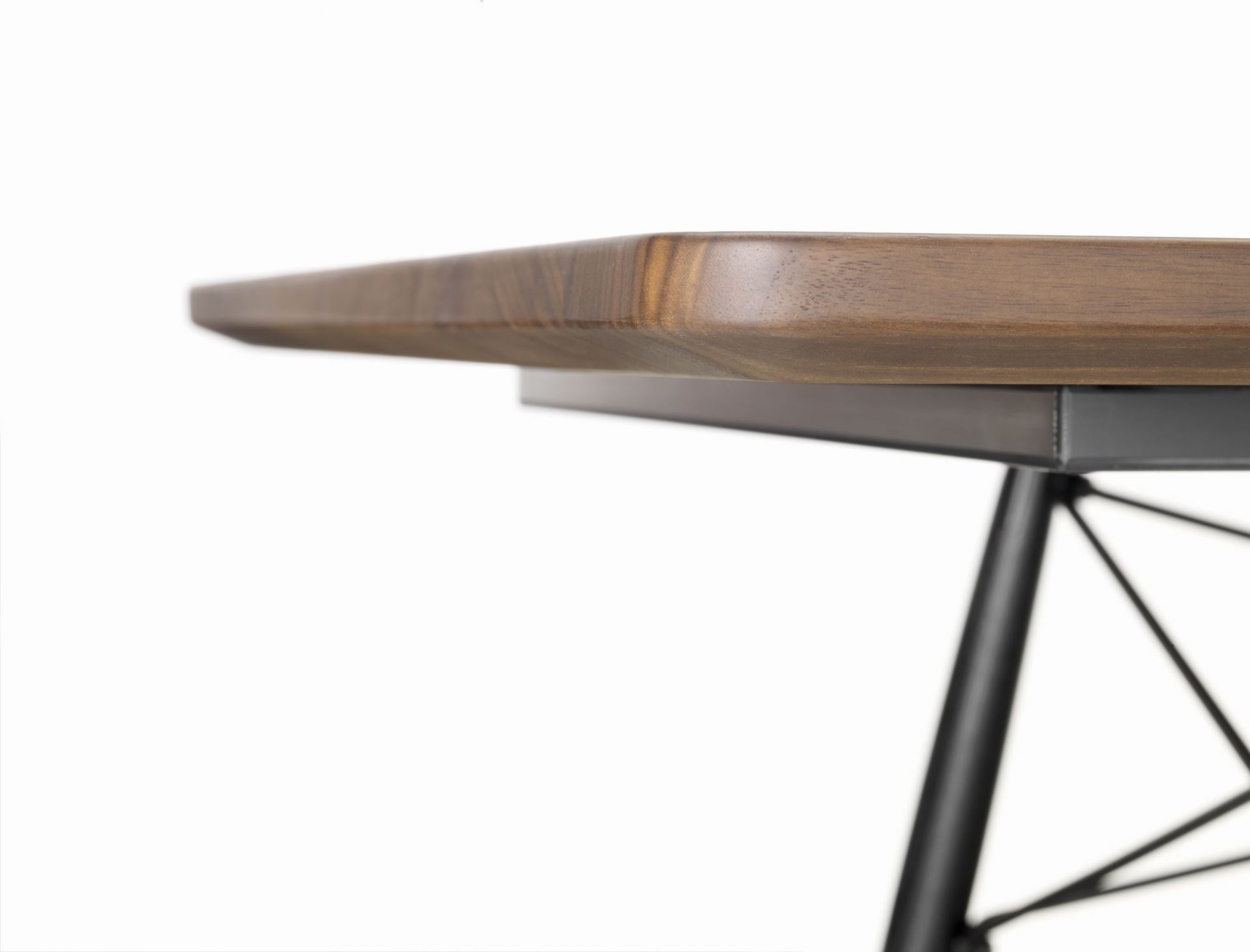 Detailaufnahme: Eames Coffee Table mit Tischplatte aus Nussbaum und schwarzem Metallgestell.