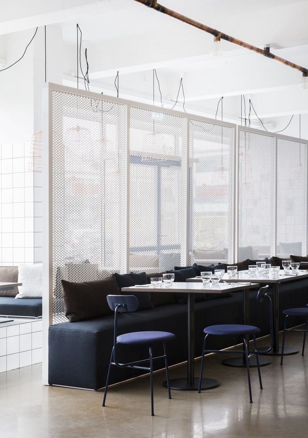 Afteroom Dining Chair von Audo Copenhagen in einem modernen Restaurant mit Sitzbänken und Tischen.