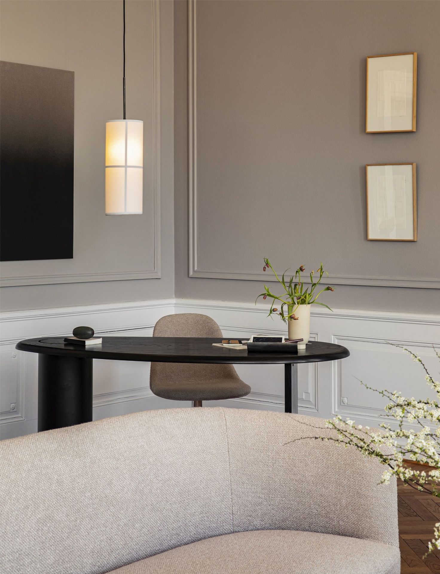 Audo Copenhagen Eclipse Desk Schreibtisch in dunklem Holz mit zylindrischem Fuß und beigem Stuhl.