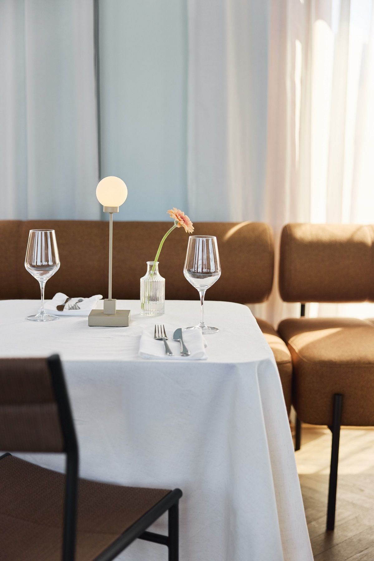 Nahaufnahme der Northern Snowball Tischleuchte auf einem elegant gedeckten Tisch im Restaurant.