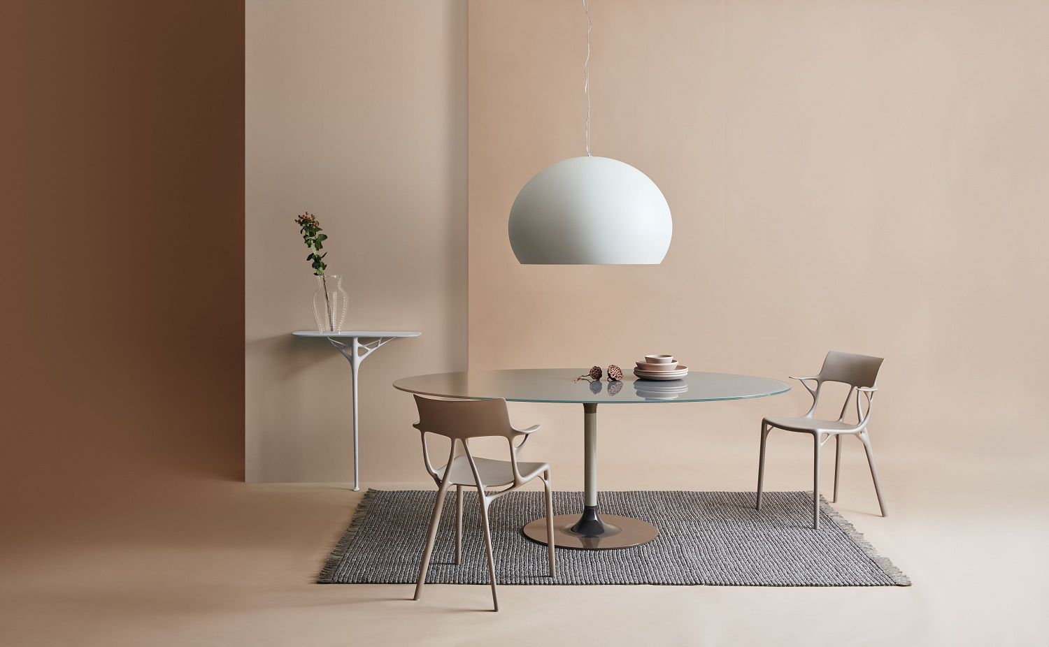 Weiße Fly Pendelleuchte von Kartell über einem Esstisch mit Stühlen in einem stilvollen Interieur.