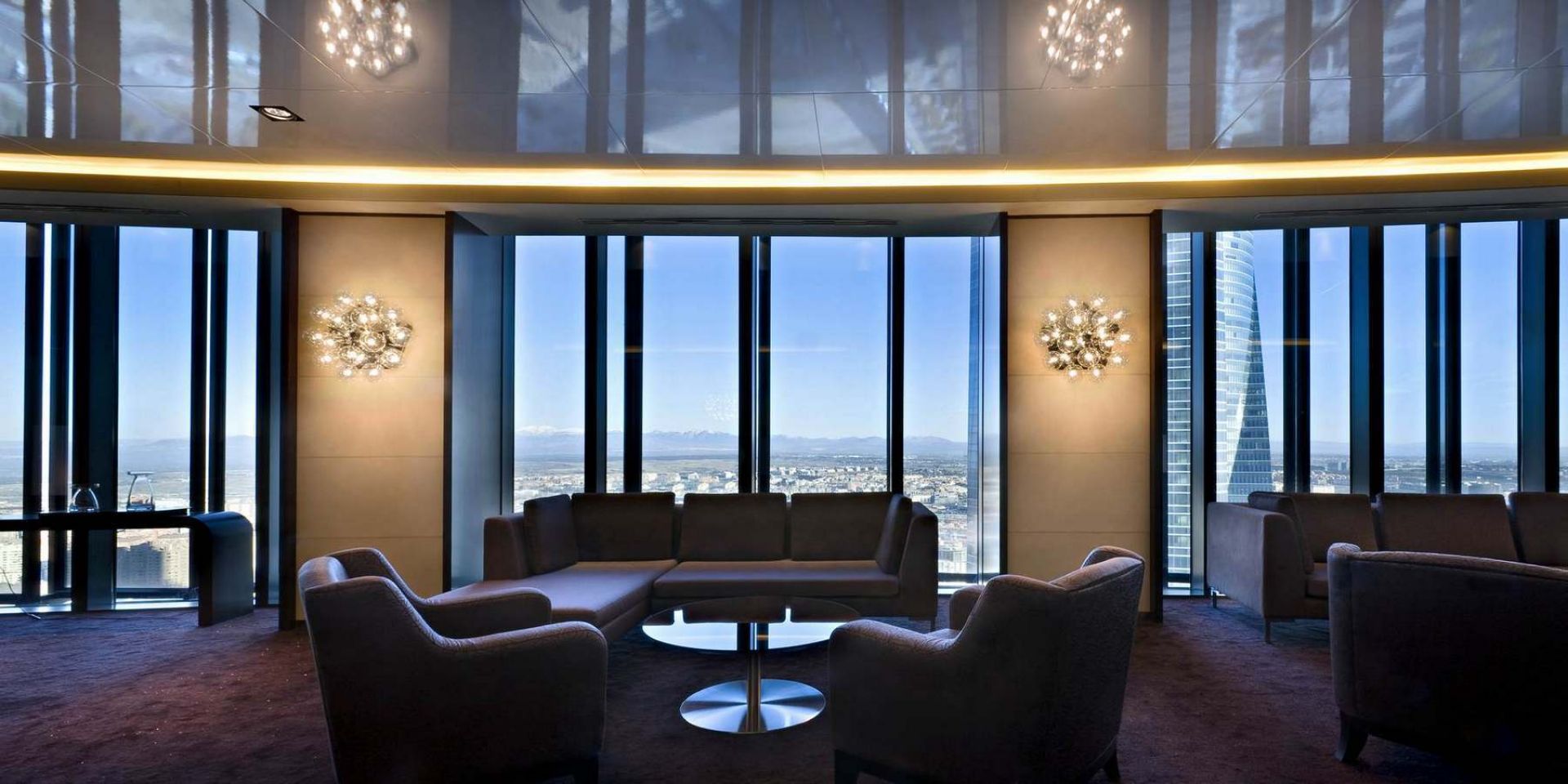 Taraxacum Wandleuchte von Flos in modernem Wohnzimmer mit Panoramafenster und Stadtblick. Design Lampe für stilvolle Innenarchitektur.