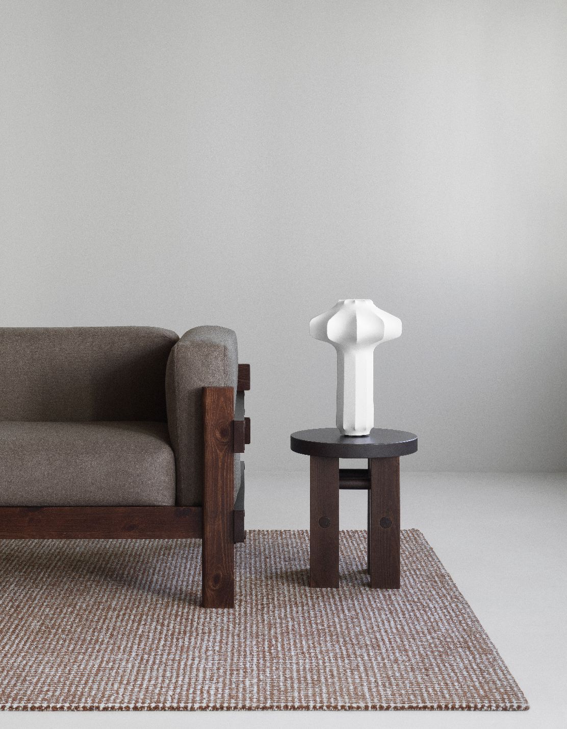 Kube Sofa von Normann Copenhagen, graues Stoffsofa mit dunklem Holzrahmen und Beistelltisch mit Lampe.