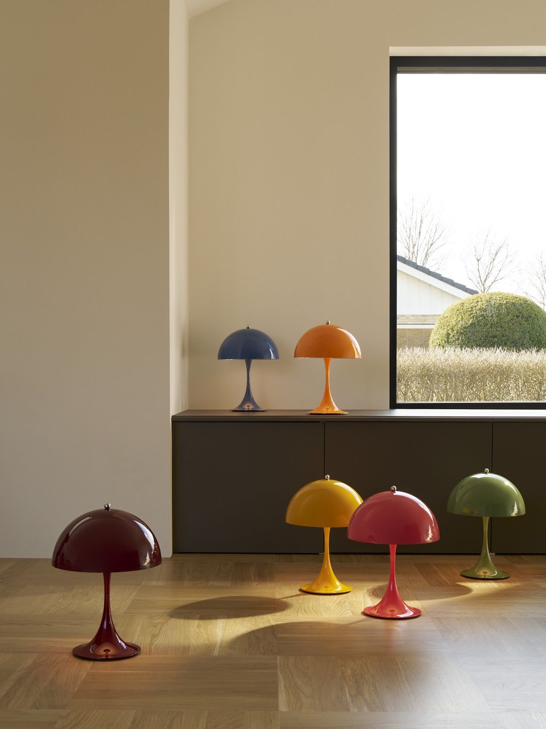 Mehrere farbige Panthella Tischleuchten von Louis Poulsen im Raum, modernes Design, stimmungsvolle Beleuchtung.