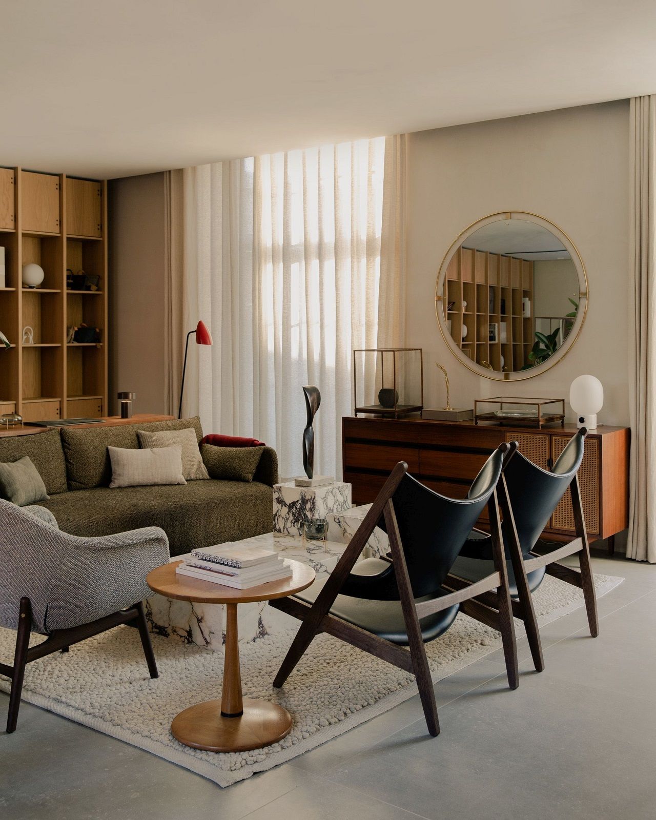 Audo Copenhagen Gravel Rug Teppich in einem stilvollen Wohnzimmer mit Sofa und Stühlen.