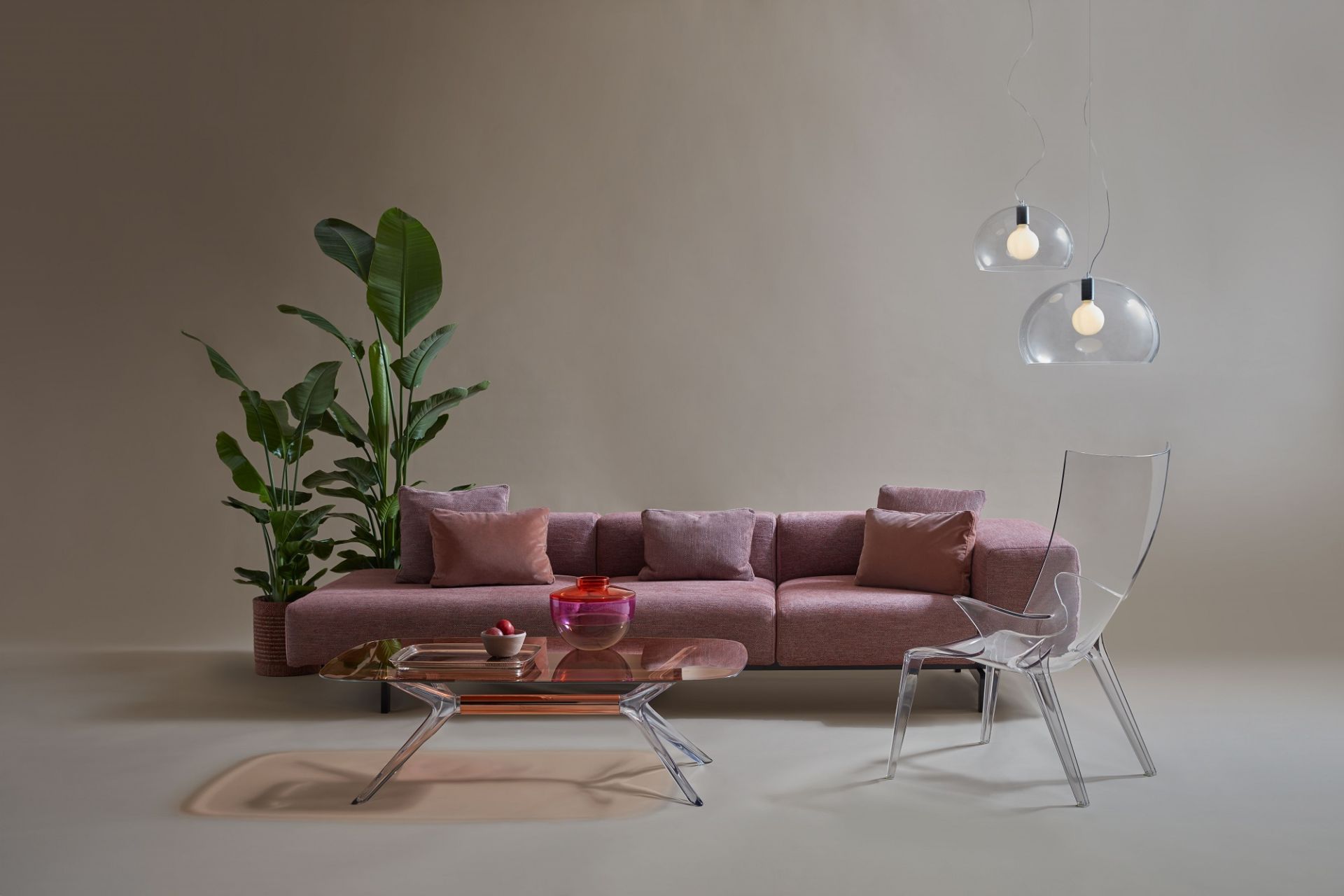 Zwei transparente Fly Pendelleuchten von Kartell über einem Wohnzimmer mit Sofa, Tisch und Stuhl.