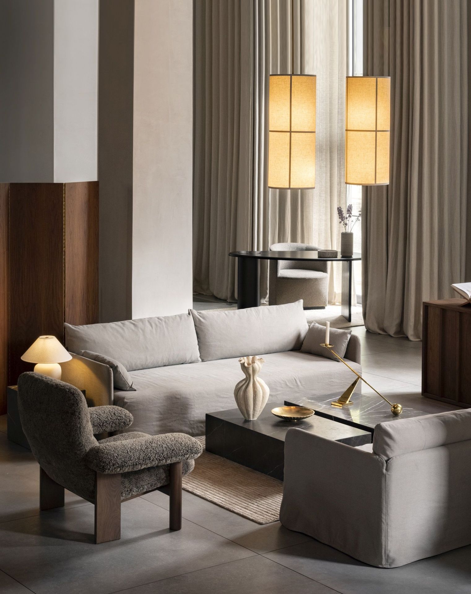 Helles Wohnzimmer mit Audo Copenhagen Offset Sofa, Sessel, Couchtisch und Pendelleuchten für gemütliches Wohnen.