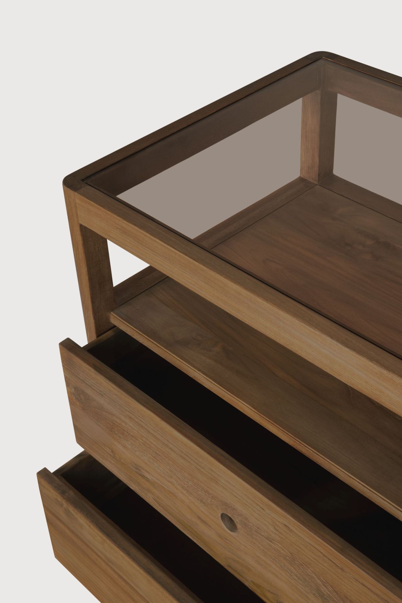 Detailaufnahme der Ethnicraft Spindle Kommode aus Teakholz mit Schubladen und Glasplatte.