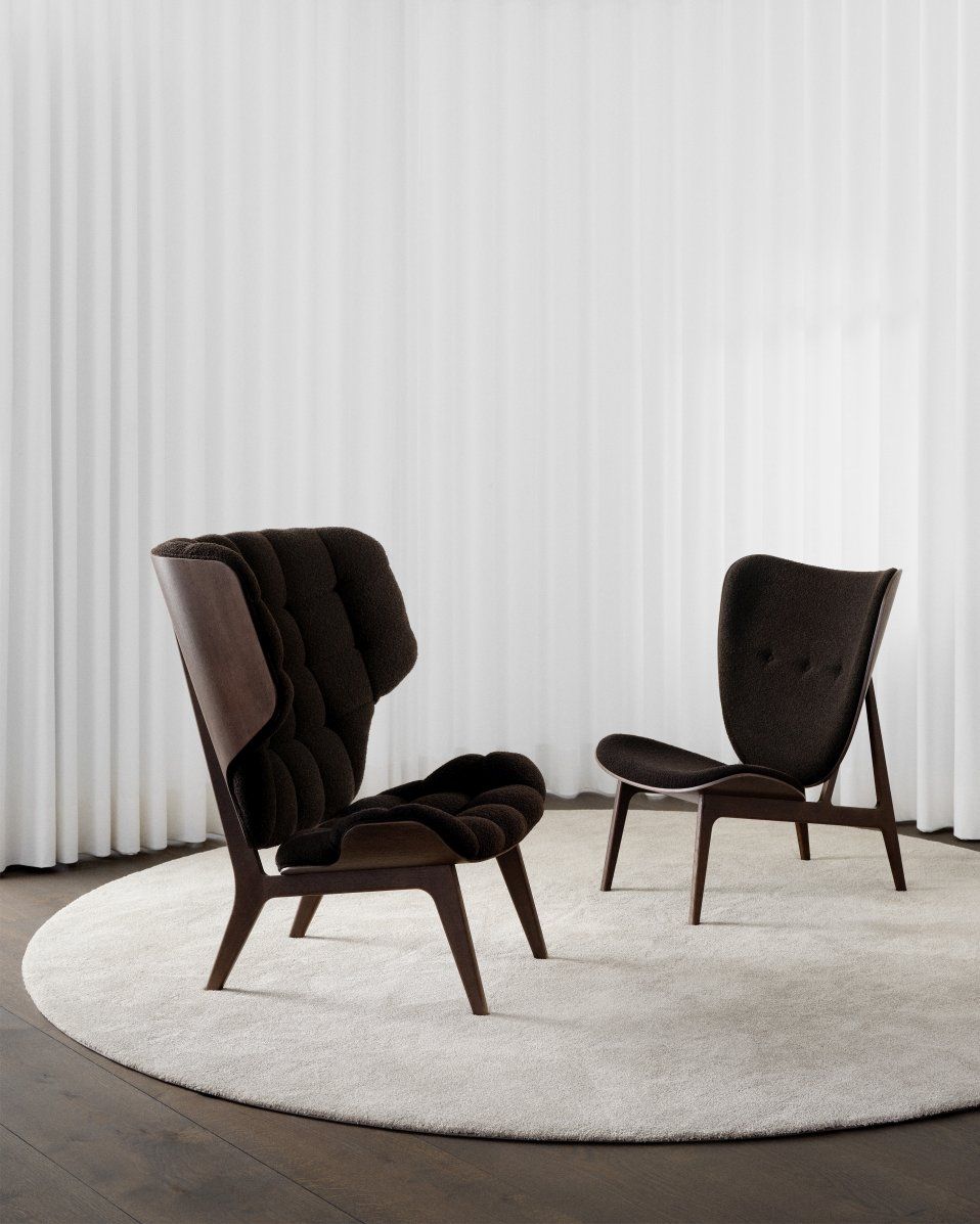 Zwei braune NORR11 Mammoth Chair Sessel aus Holz und Stoff auf einem Teppich.