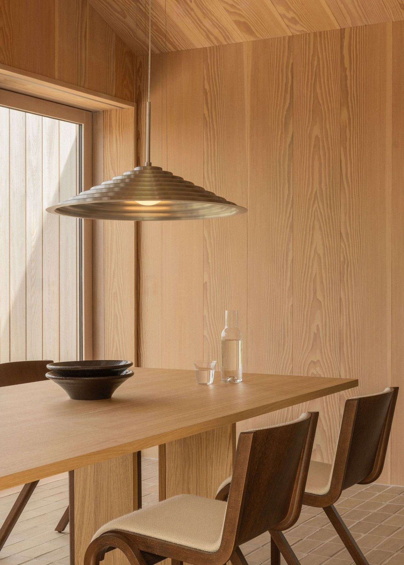 Audo Copenhagen Ready Dining Chair mit Vollpolsterung an einem Esstisch mit Geschirr.