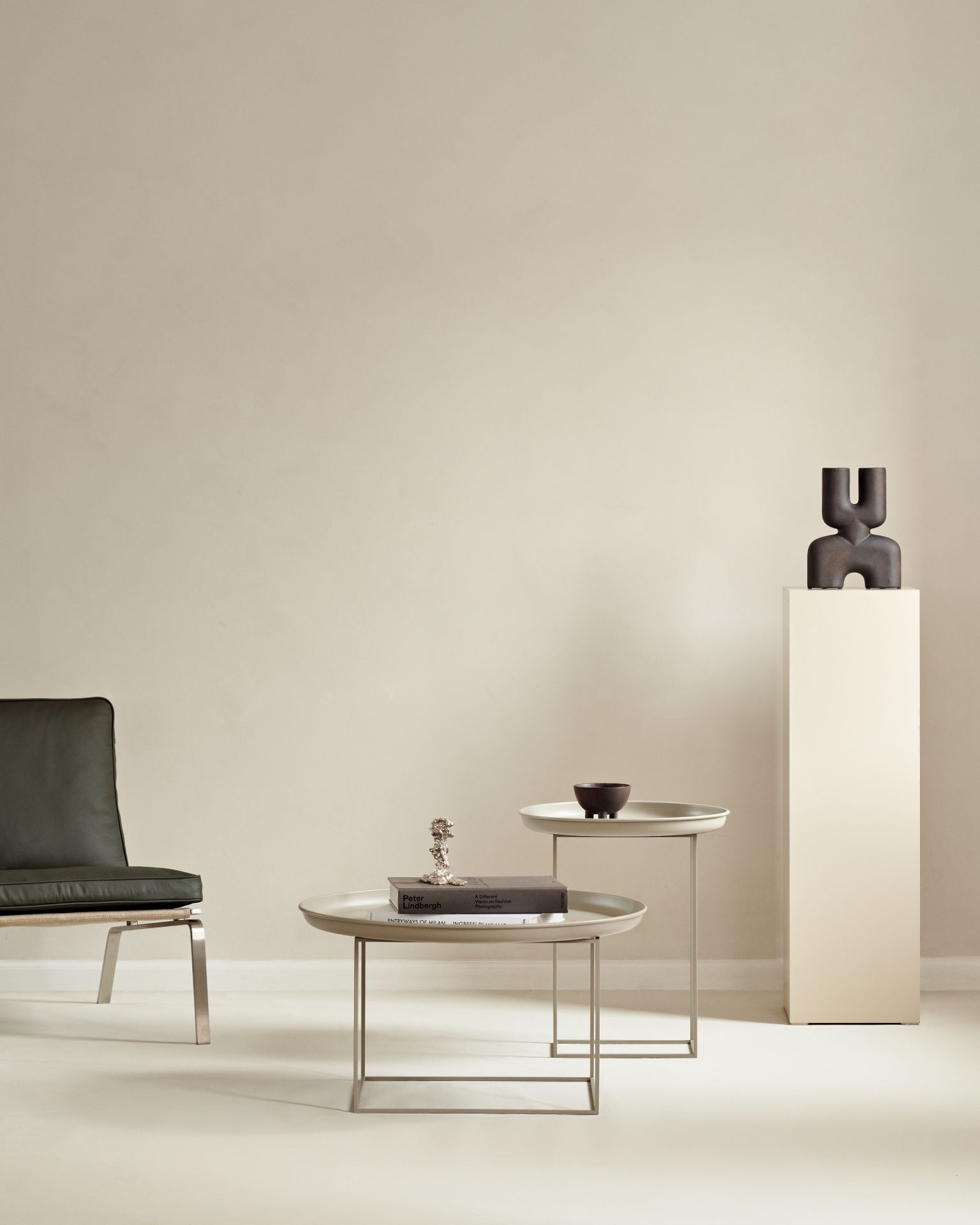 Norr11 Duke Small Side Table Beistelltisch im minimalistischen Wohnzimmer mit Dekoration und Sessel.