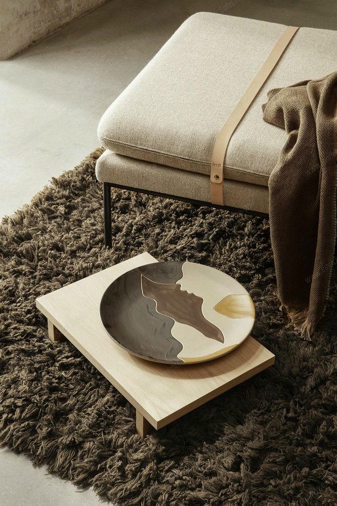 Nahaufnahme der Ferm Living Turn Daybed Liege in Dunkelgrün, kombiniert mit Teppich und Dekoschale.