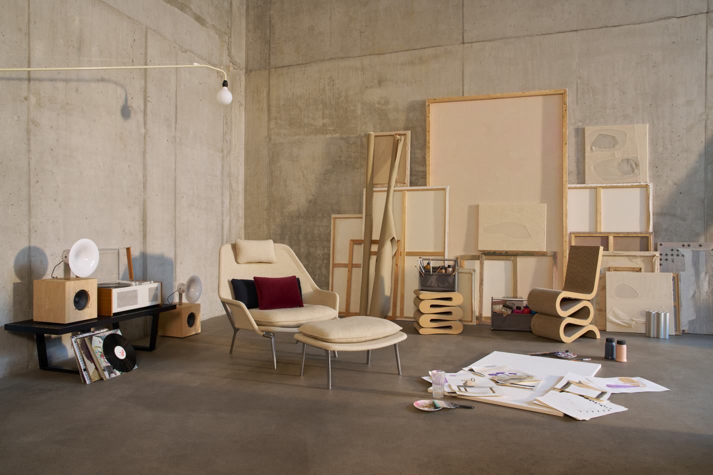 Vitra Slow Chair mit Ottoman aus Stoff in hellem Beige, modernes Wohnzimmer-Interieur mit Kunst.