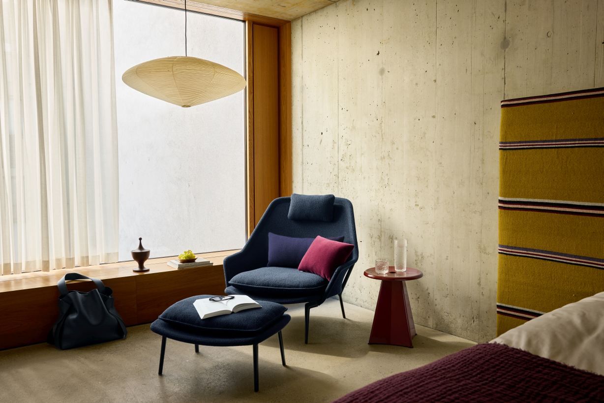 Vitra Slow Chair mit Ottoman im Wohnzimmer, blauer Stoffbezug, bequemer Sessel mit Fußhocker.