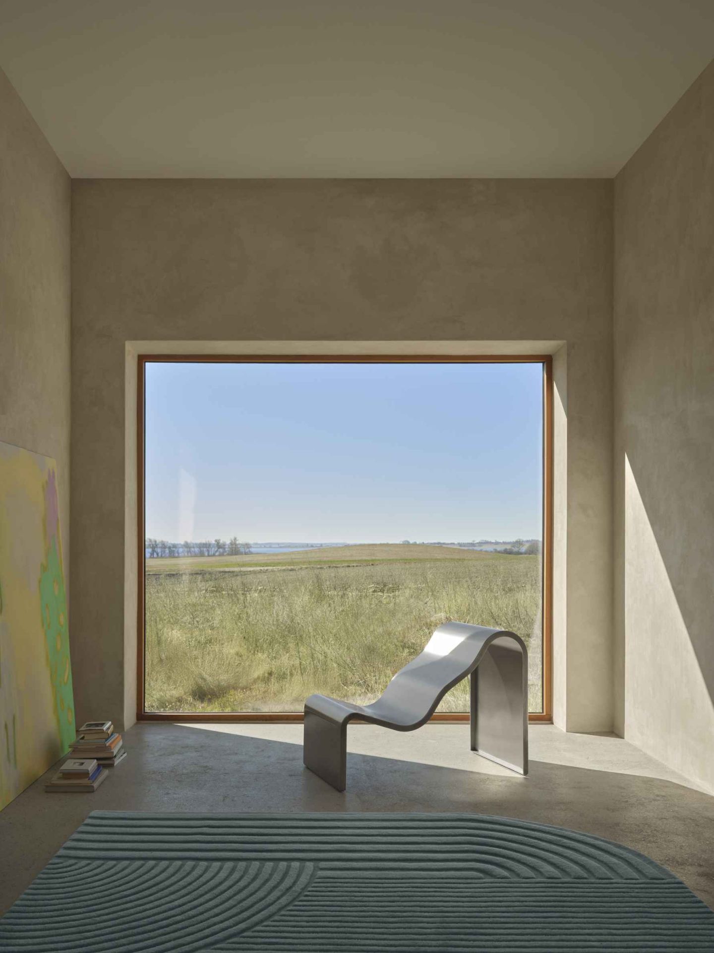 Helle Inneneinrichtung mit Dream Bench Bank von Muuto, minimalistisches Design, Blick auf grüne Landschaft durch großes Fenster.
