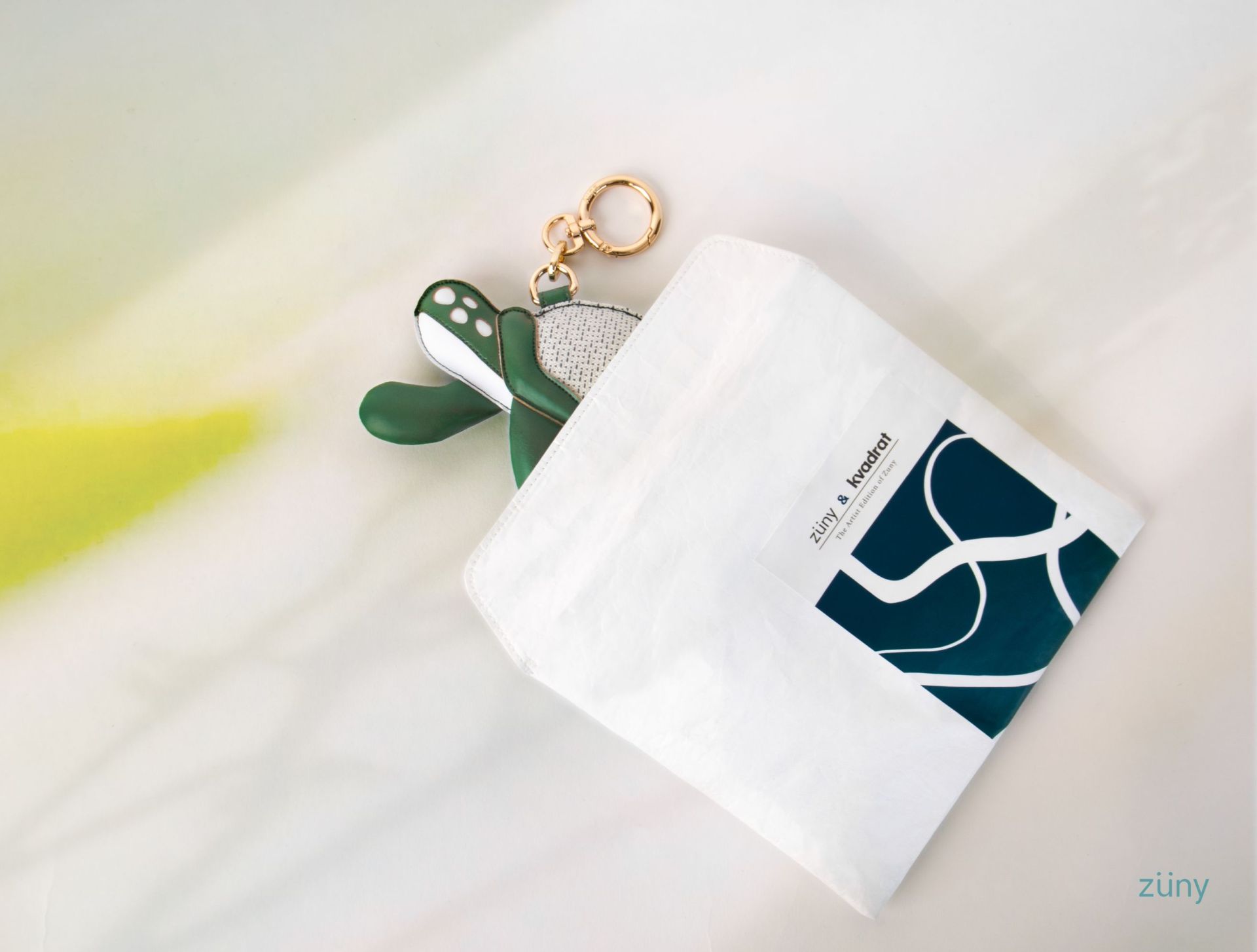 Bag Charm Schildkröte Toby Züny x KVADRAT aus Lederimitat mit goldenem Schlüsselring in Verpackung.