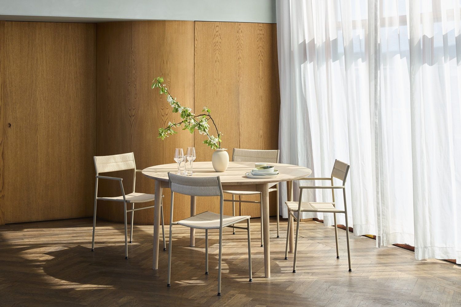 Vev Dining Chair Stuhl von Northern um einen runden Esstisch aus hellem Holz.