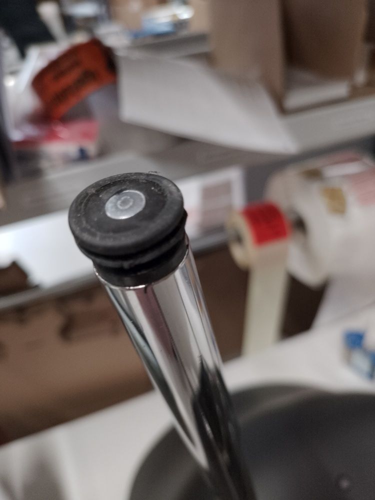Detailaufnahme vom Fuß eines About A Chair AAC26 Stuhls mit Chromgestell und schwarzem Fußgleiter.