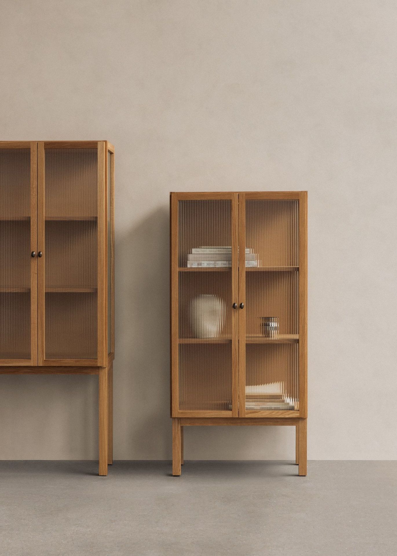 Audo Copenhagen Curiosity Cabinet: Zwei Holzschränke mit geriffeltem Glas, ideal für Wohnzimmer und Esszimmer.