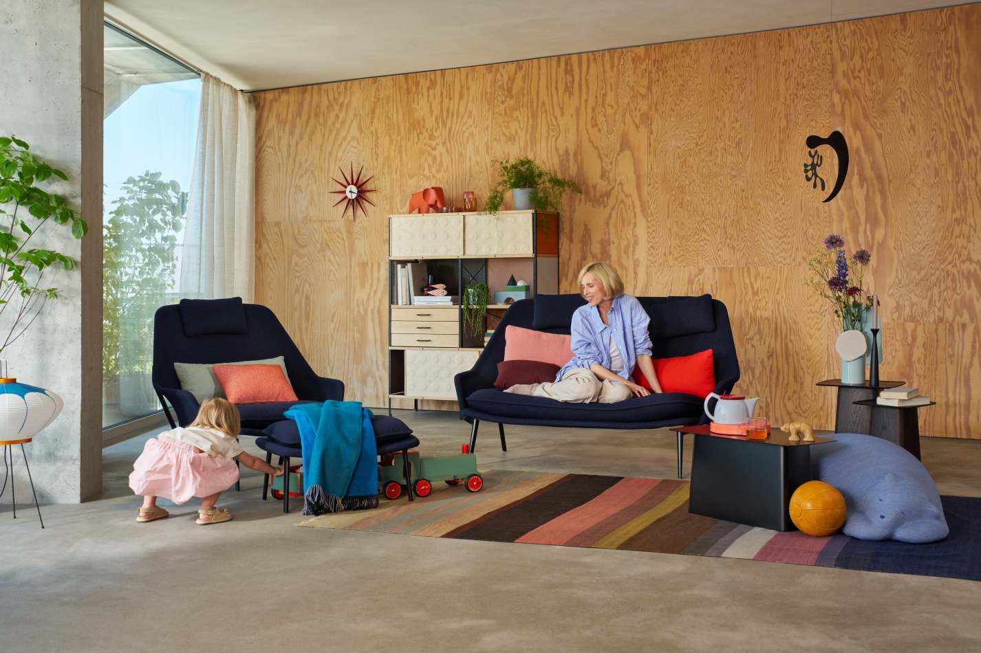 Vitra Slow Sofa mit Stoffbezug in modernem Wohnzimmer mit Frau und Kind.