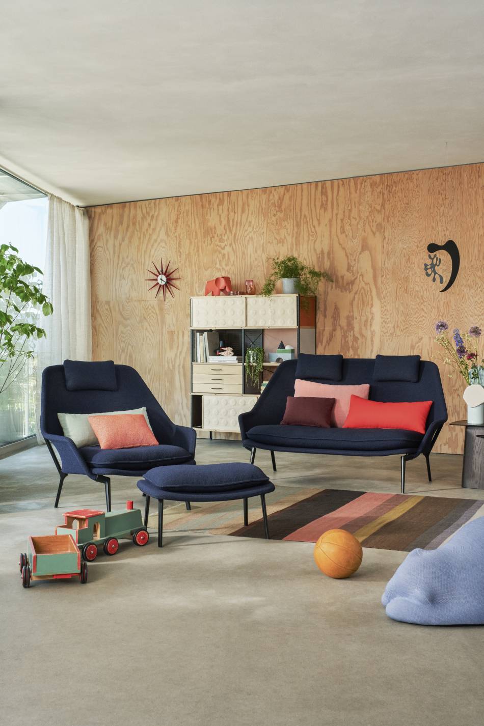 Vitra Slow Chair Sessel und Sofa in blauem Stoffbezug mit Hocker in modernem Wohnzimmer.