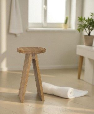 Heller, minimalistischer Raum mit einem Hocker groß EK02 von e15 aus hellem Holz.